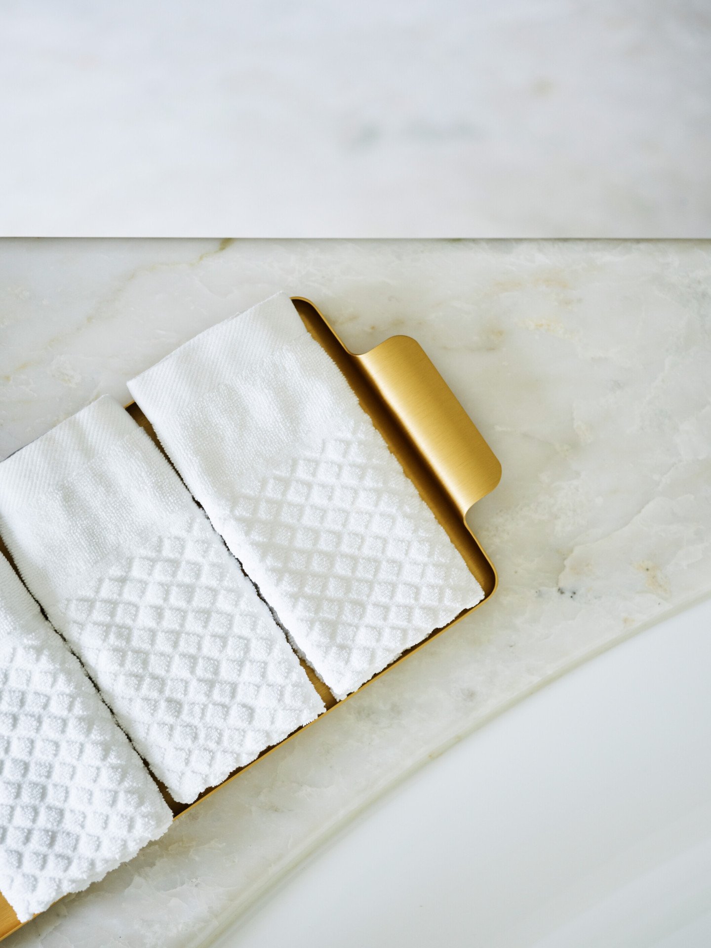White towels on marble surface inside bathroom of Bellavista penthouse suite at Hotel Eden, Rome