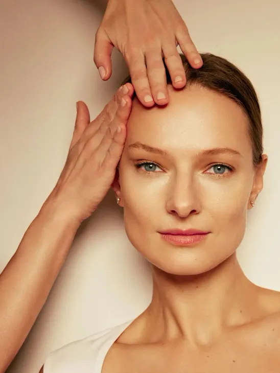 Model receiving treatment for spa masterclass demonstration for Natura Bissé in warm lighting