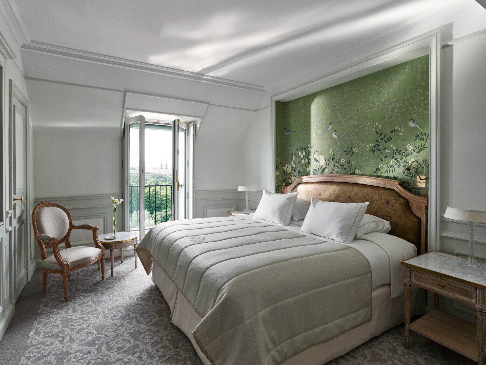 Bedroom side of the superior room, with a green hand painted wall and the view on the Tuileries Garden in the distance. At Le Meurice, Paris.