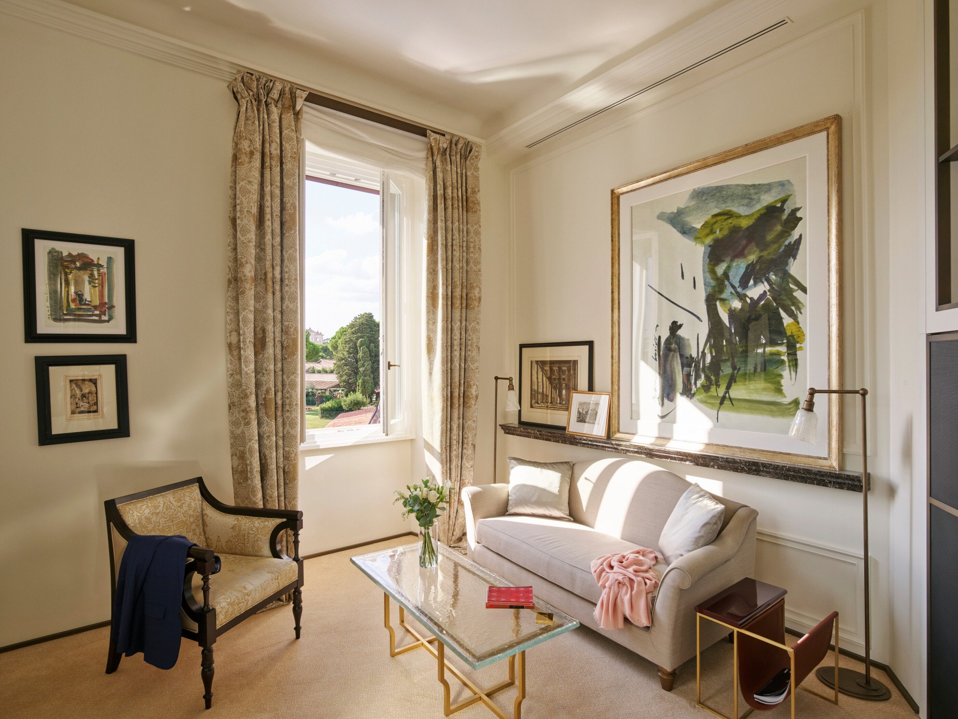 Living room with couch, armchair, paintings and coffee table at Classic Suite with view at Hotel Eden, Rome
