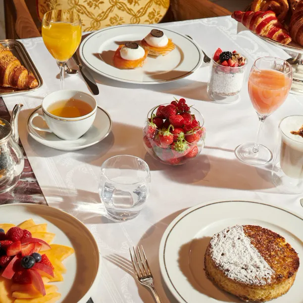 Images of the brunch in room Images of the brunch at the Jean Imbert au Plaza Athénée. We can see a fruit salade , pastries, coffee, eggs and juices