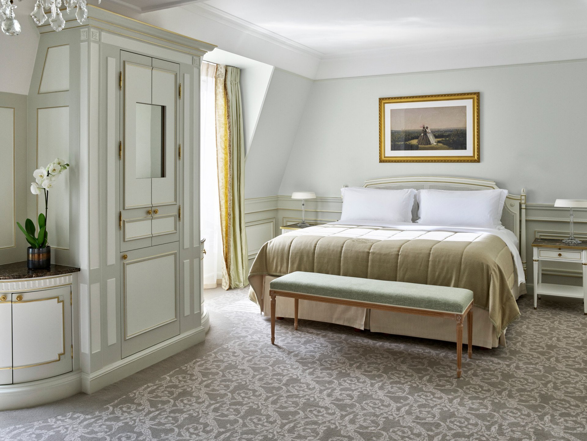 Overview of the bedroom side in a deluxe junior suite, with light green undertones at Le Meurice, Paris.