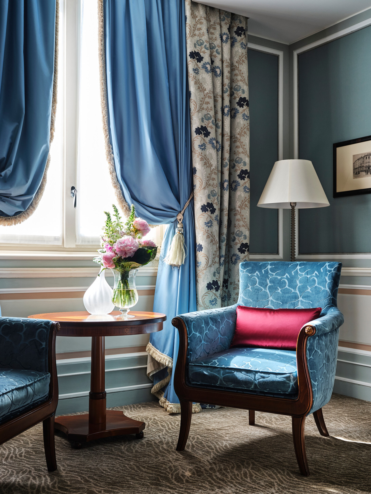 Detail shot of a Mosaic room including an armchair and flowers by the window