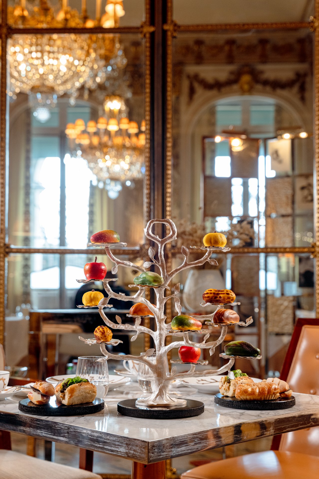 Elegant dessert display with macarons and pastries on a decorative tree in a luxurious setting