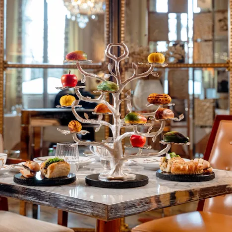 Elegant dessert display with macarons and pastries on a decorative tree in a luxurious setting