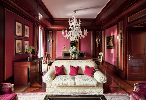 Royal Suite Living Room Overview revealing a predominantly red décor and a contrasting white sofa in the foreground