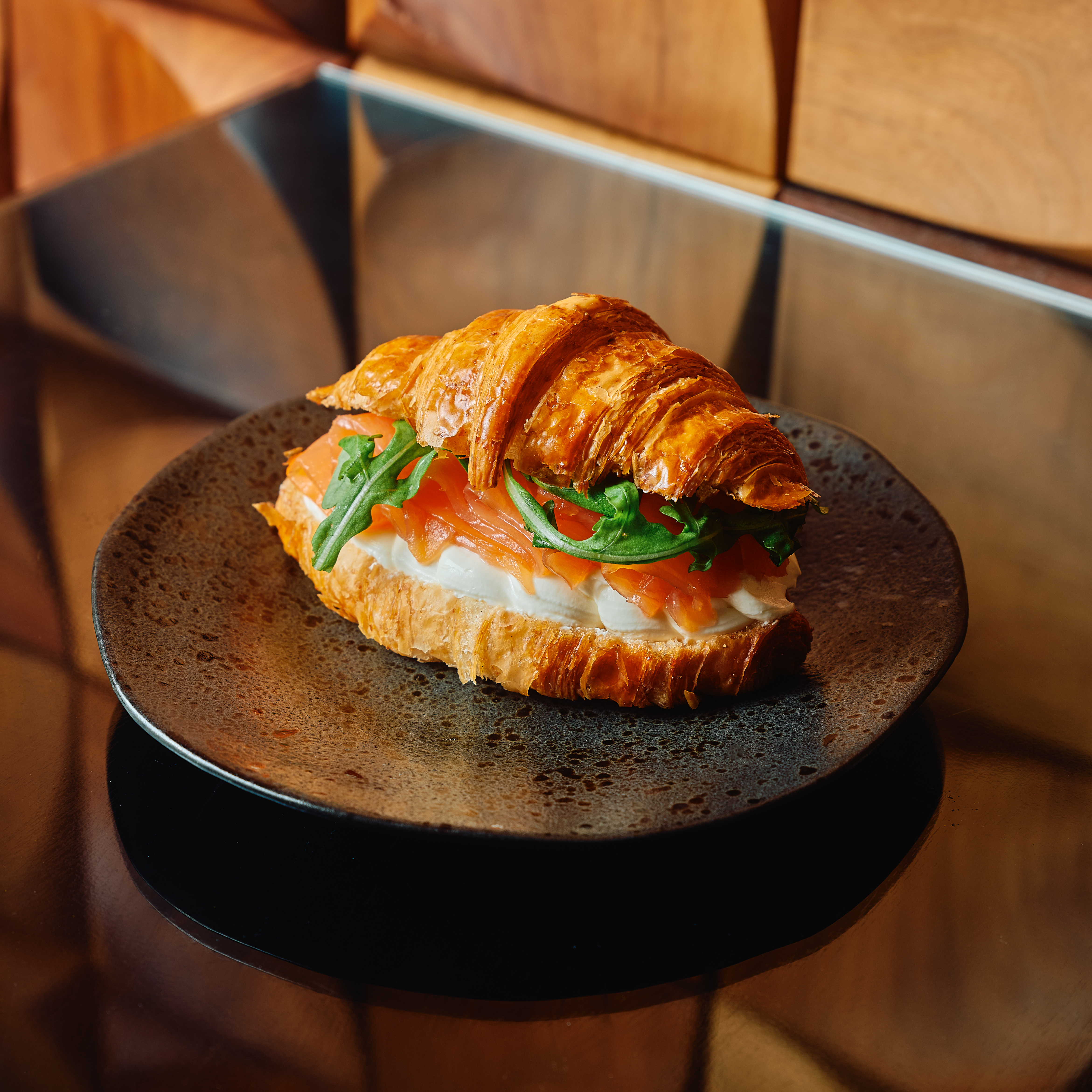 Smoked salmon and cream cheese croissant on grey plate at Parcafe