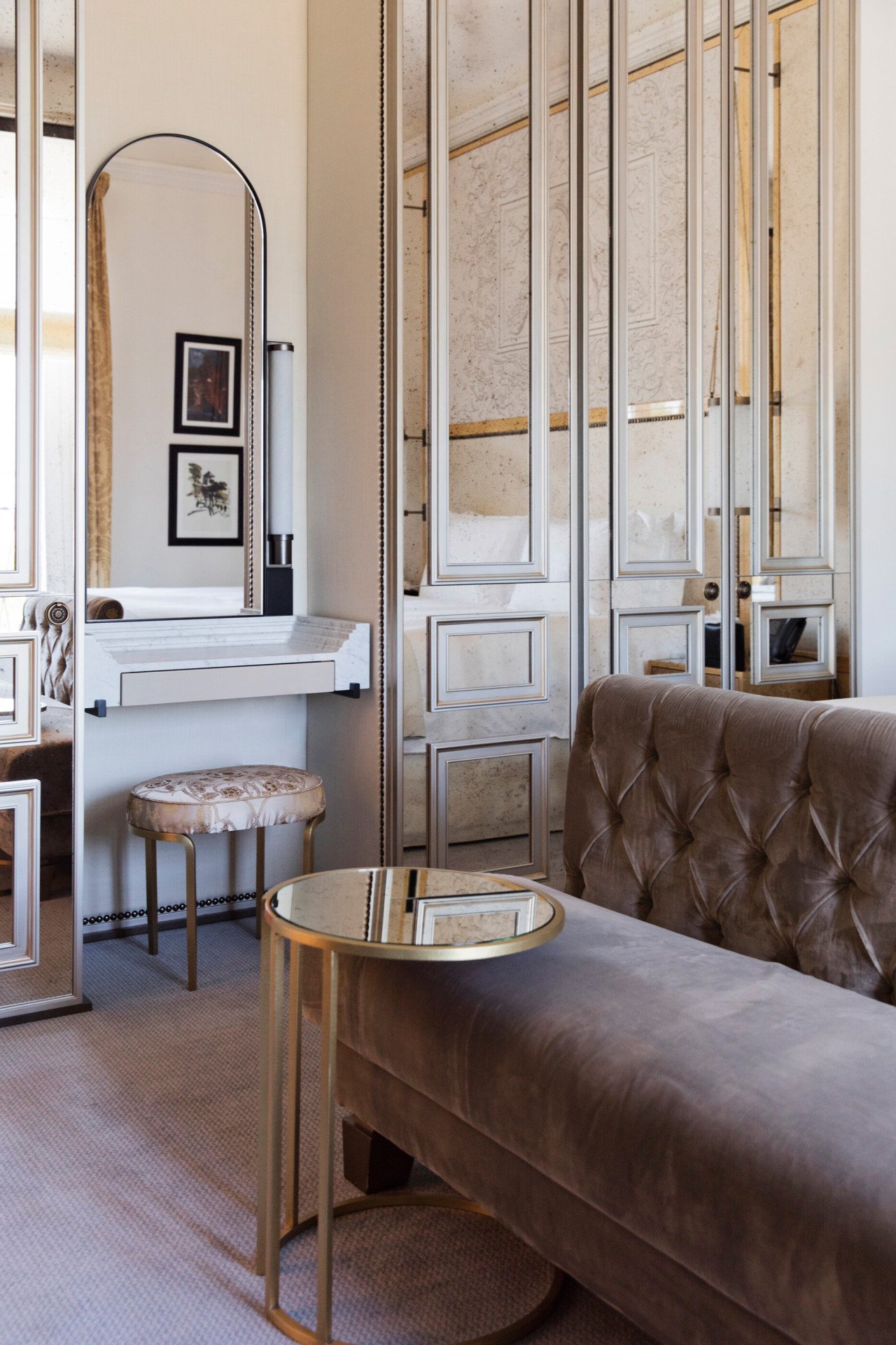 Elegant bedroom with grey couch and vanity station at Hotel Eden, Rome