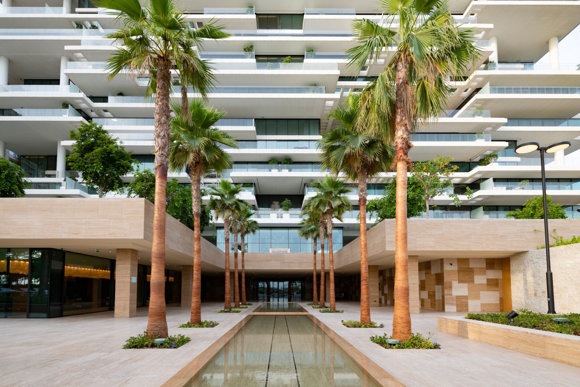Palm tree-lined water feature in front of One at Palm Jumeirah, Dubai