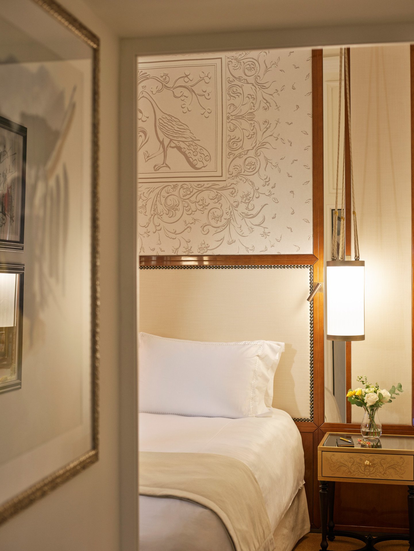 Bedroom of Classic room with bouquet of flowers on night stand and lit lamp at Hotel Eden, Rome
