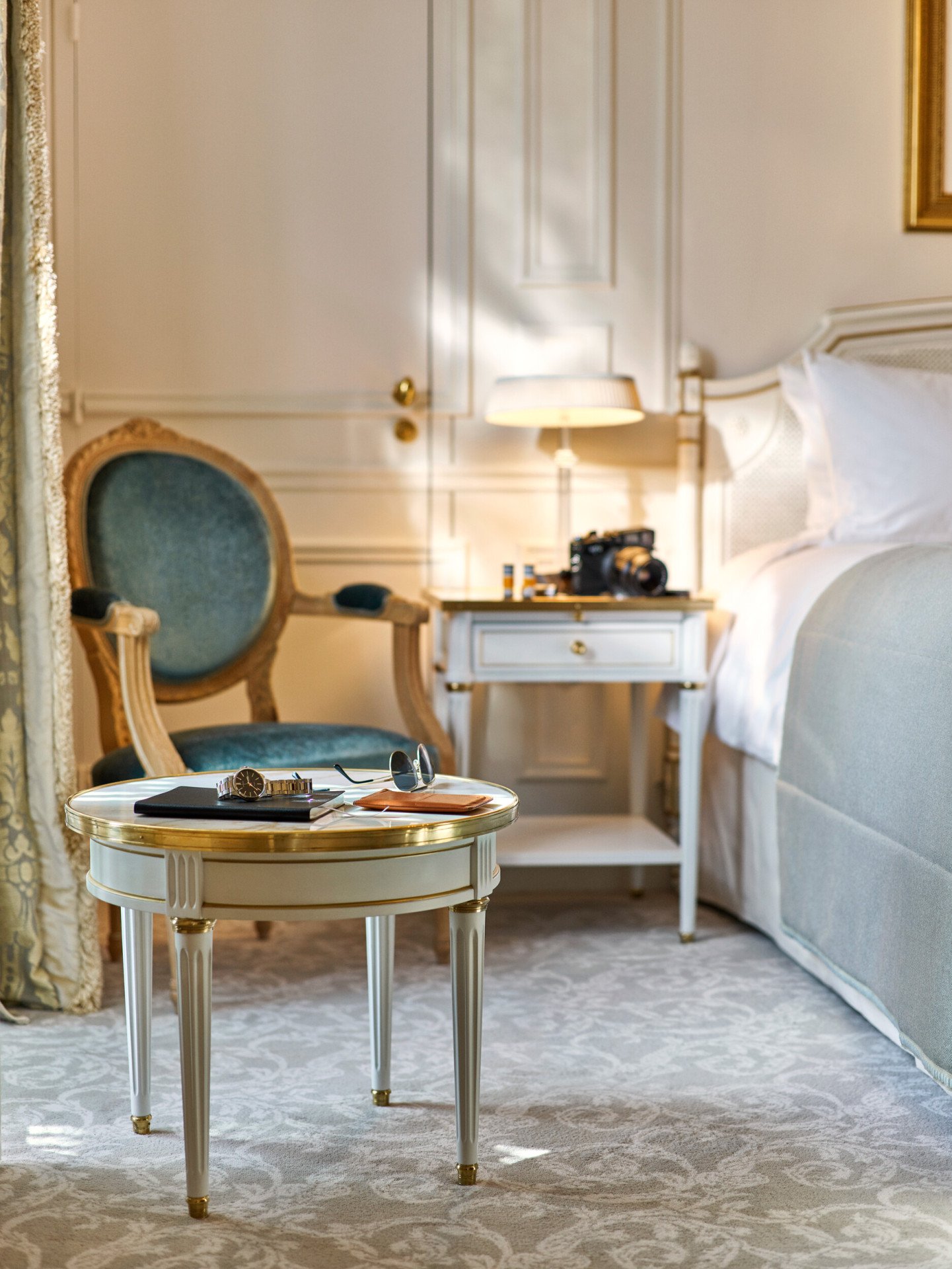 Sunglasses, a watch and a notebook placed on a table by the bed in an executive room. At Le Meurice, Paris.