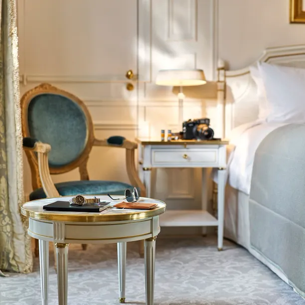 Sunglasses, a watch and a notebook placed on a table by the bed in an executive room. At Le Meurice, Paris.