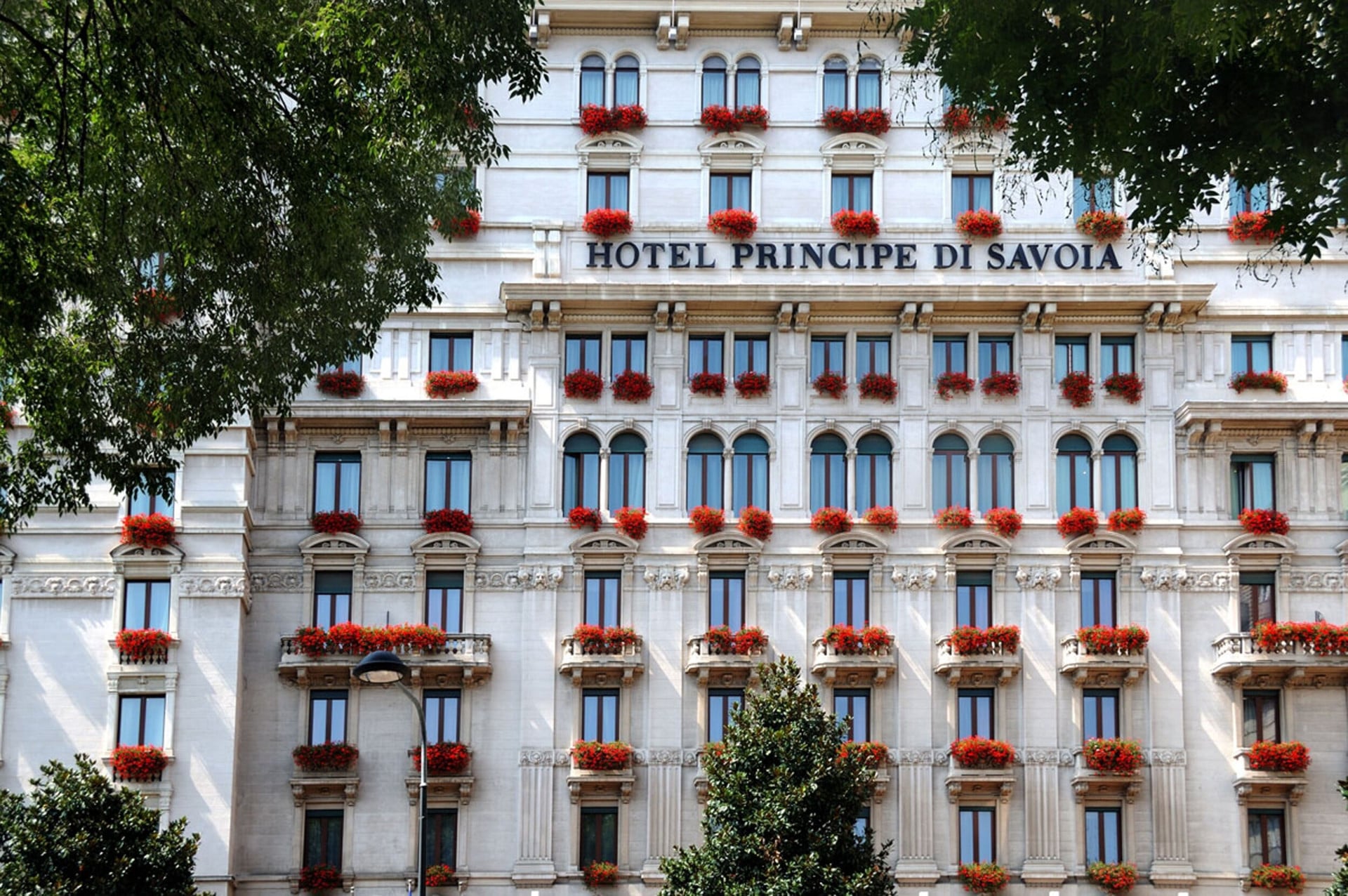 Hotel Principe di Savoia facade with red flowers on the balconies front view
