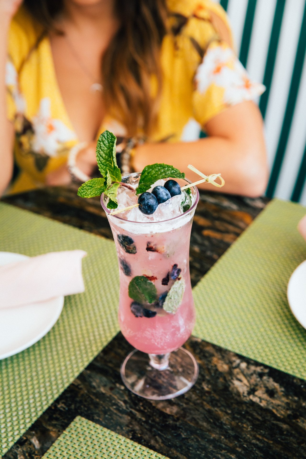 Woman drinking blueberry lavender fizz from the Cabana Cafe 