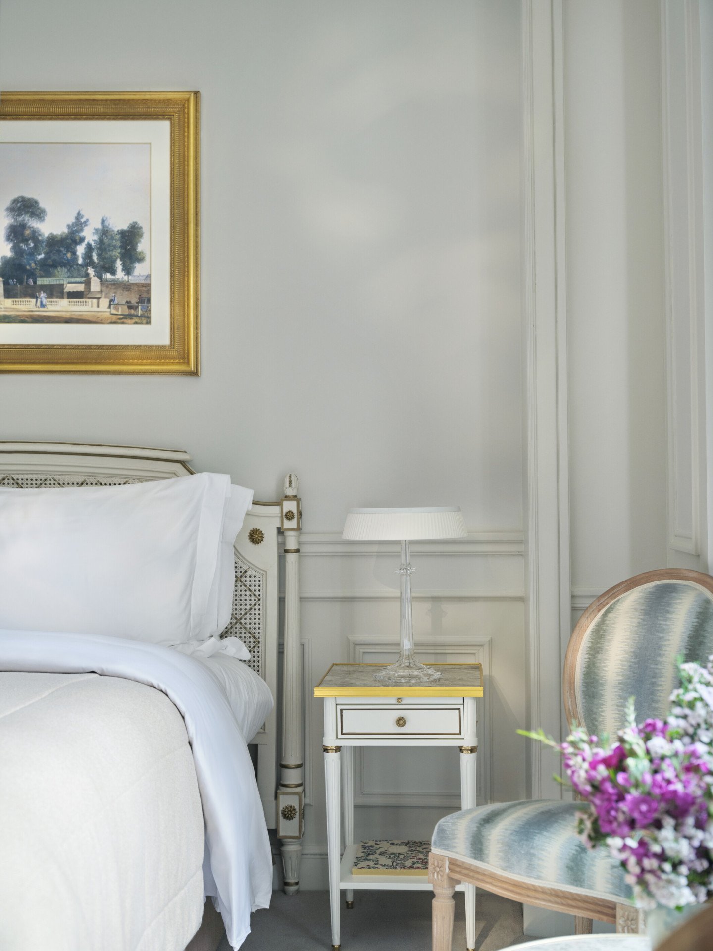 Picture centred on the left side of the bed with the details on the flowers and a chair, at Le Meurice, Paris
