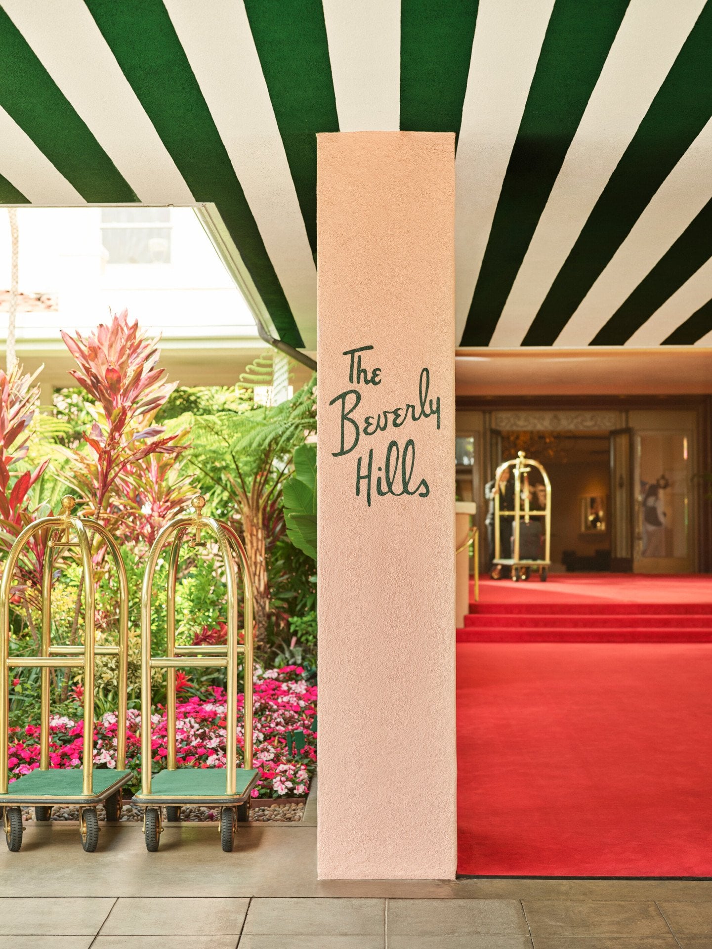 The Beverly Hills Hotel red carpet entrance with bellman carts in front. 