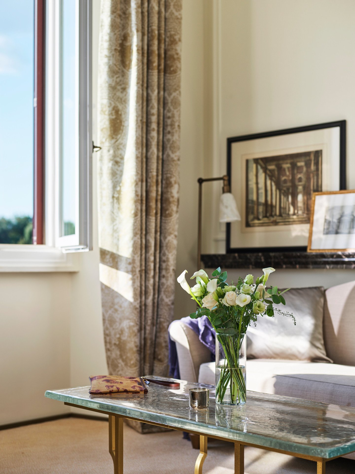 Detail of coffee table with bouquet of flowers and couch of Classic suite with view at Hotel Eden, Rome