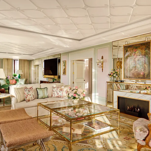 Elegant living room with vintage furniture, fireplace, floral decor, and a cozy atmosphere