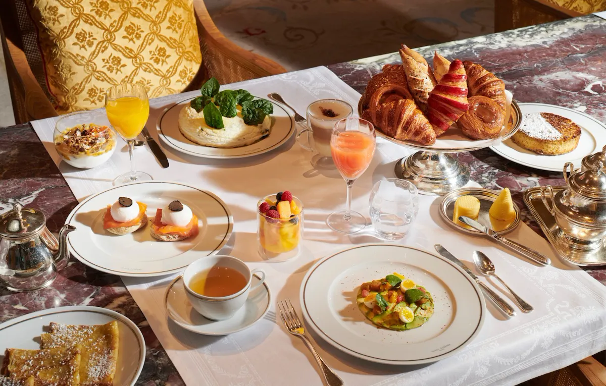 Images of the brunch in room Images of the brunch at the Jean Imbert au Plaza Athénée. We can see a fruit salade , pastries, coffee, egss, crepes, avocadoand juices