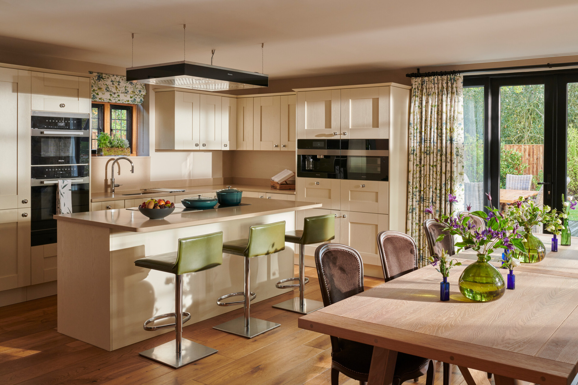 Bright kitchen with a dining area, flowers, and sliding glass doors to the garden.