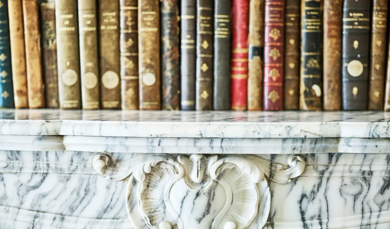 Books on top of a marble furniture piece in the presidential appartment at Le Meurice, Paris.