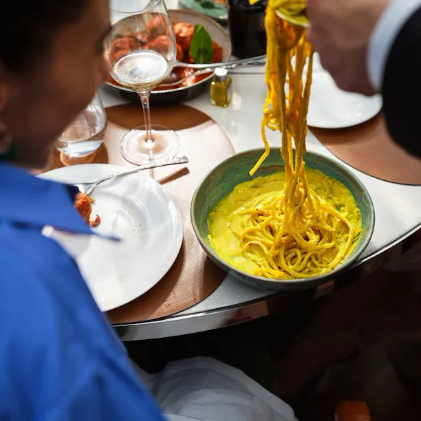 Close up of waiter serving spaghetti at Il Giardino Ristorante, Hotel Eden