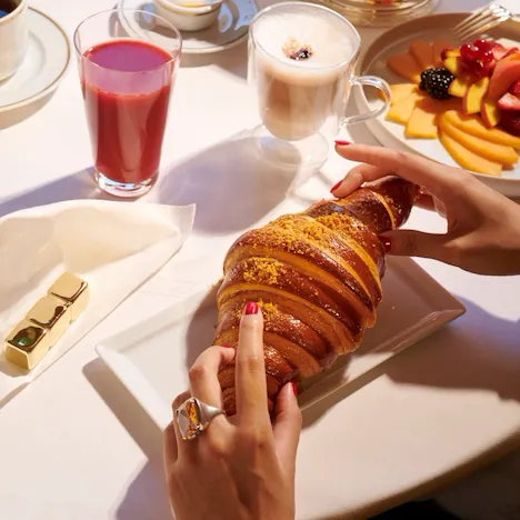 Images of the brunch at the Jean Imbert au Plaza Athénée. We can see a hand picking a croissant