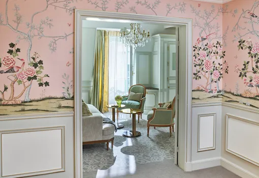 Distant shot of the living room, highlighting the pink wallpaper in the room, at Le Meurice, Paris.