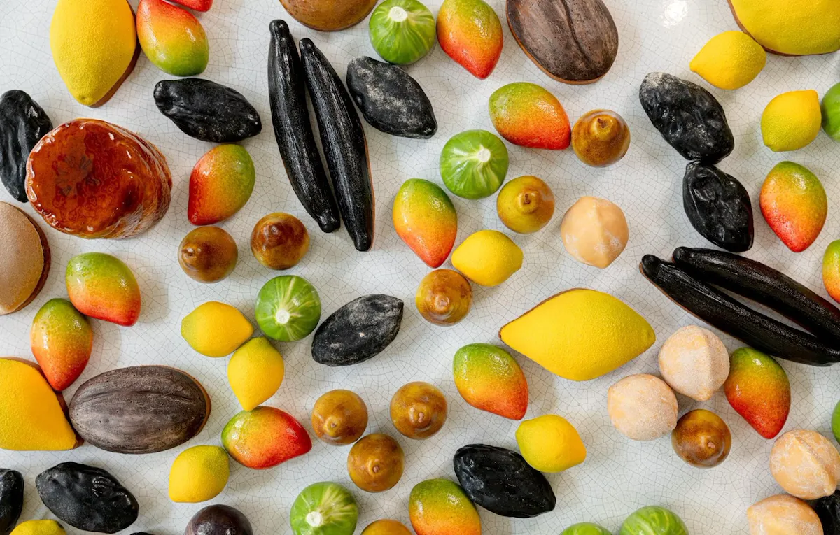 We can observe a large panel of fruit pastries, "trompe l'oeil" style, from a top view. Among them : lemons, vanilla beans, pears, mangoes and more, at Le Meurice, Paris.