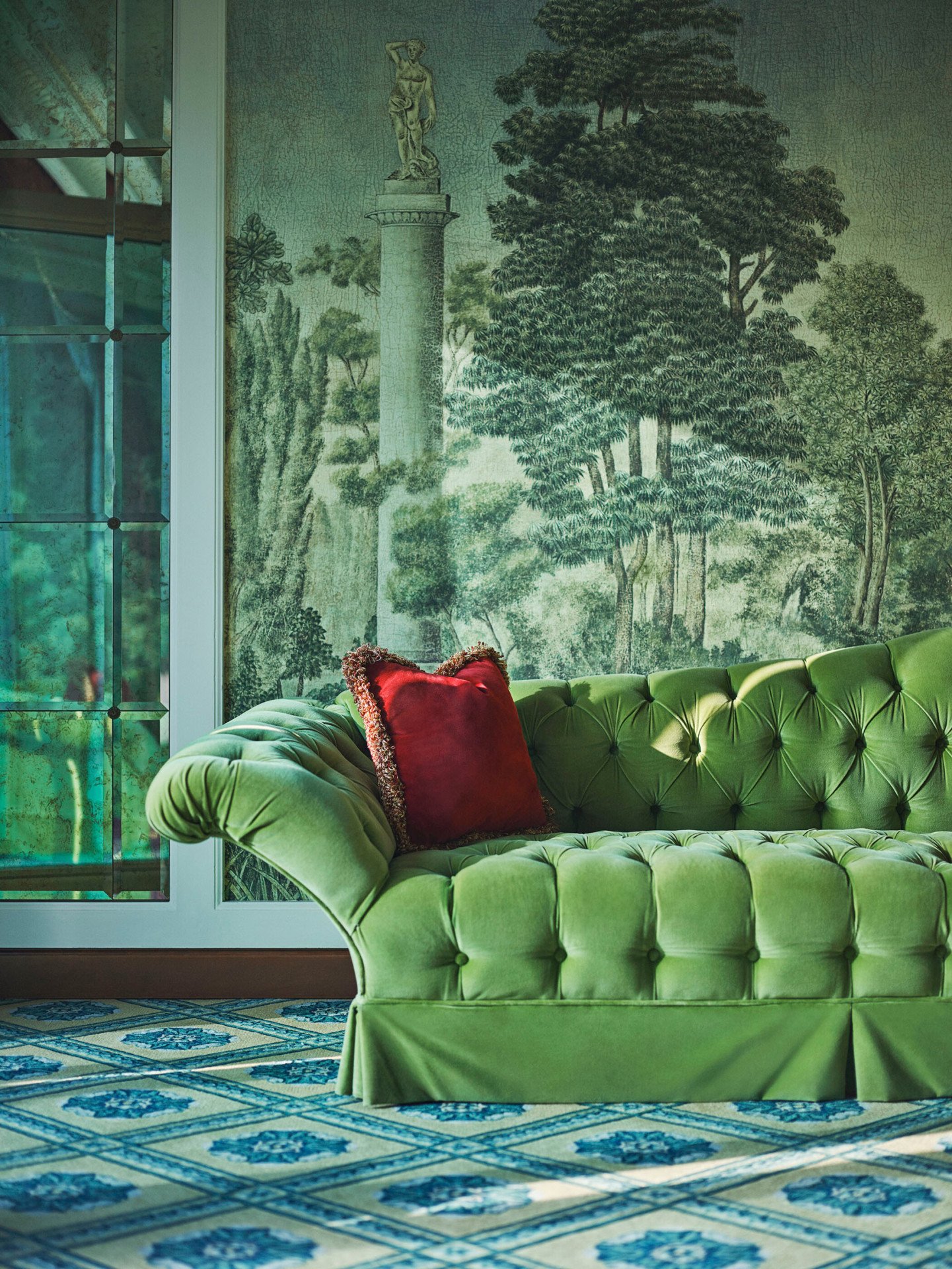 Green velvet sofa with red cushion in the second bedroom of Presidential Suite