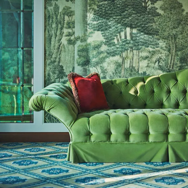 Green velvet sofa with red cushion in the second bedroom of Presidential Suite
