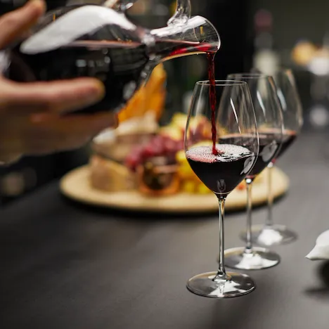 Red wine being poured into glaswarein the wine vault at the dorchester