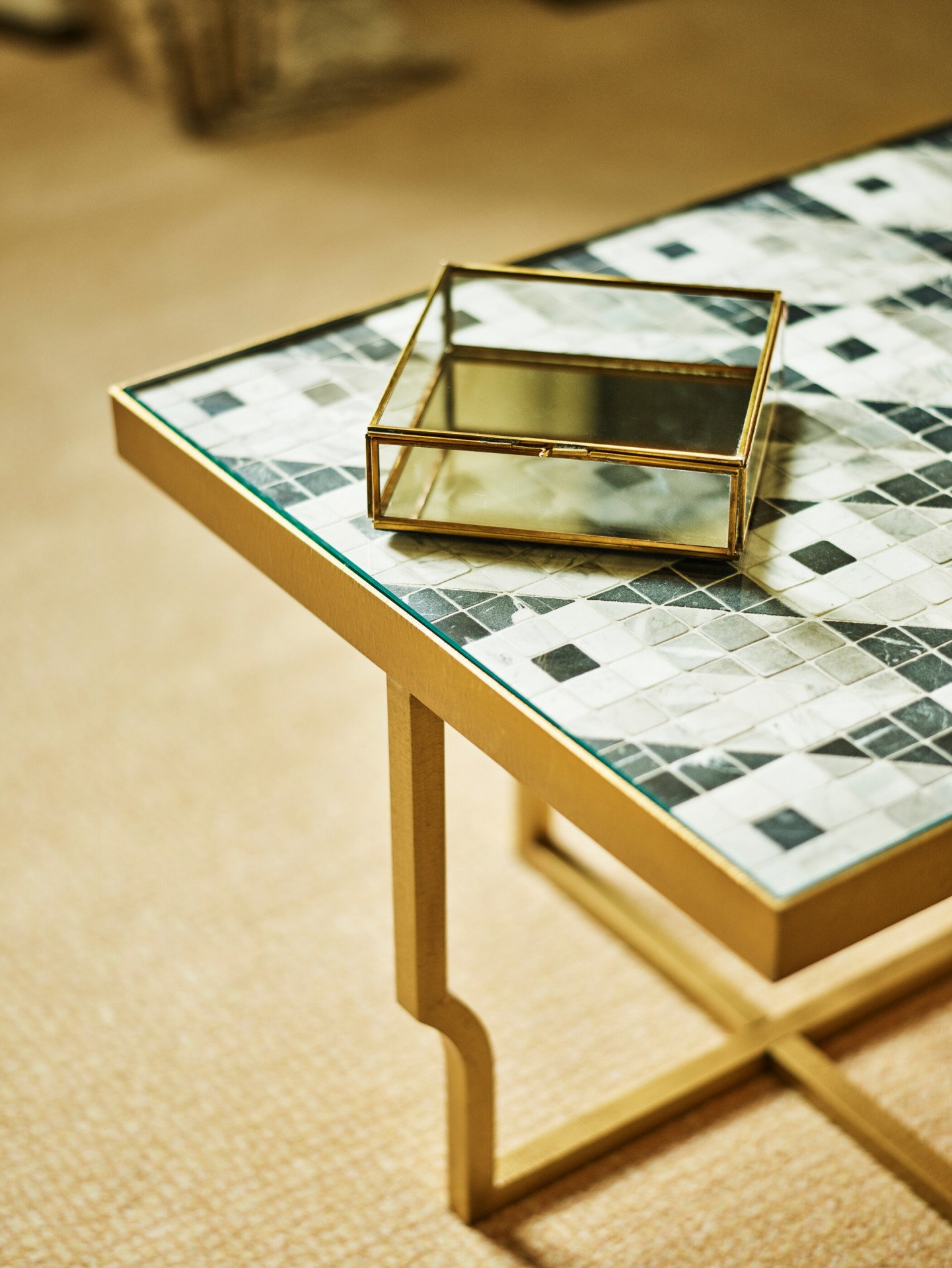 Black and white coffee table with golden base and glass container on top at Prestige Suite at Hotel Eden, Rome