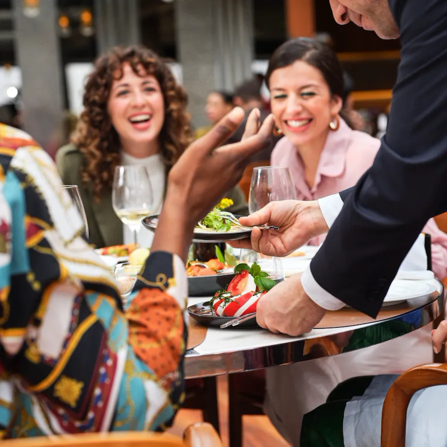 Close up on table composed by friends cheering at Il Giardino Ristorante, Hotel Eden