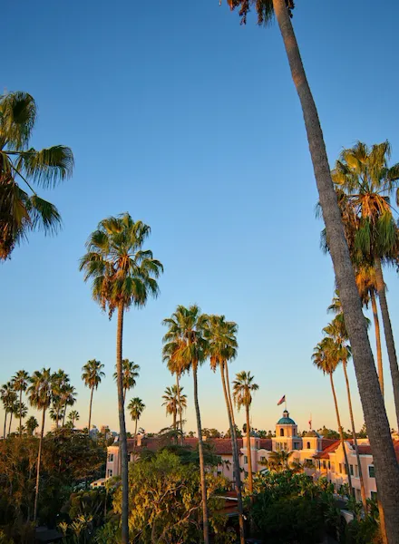 The exterior of The Beverly Hills Hotel with palm trees at sunset, Los Angeles