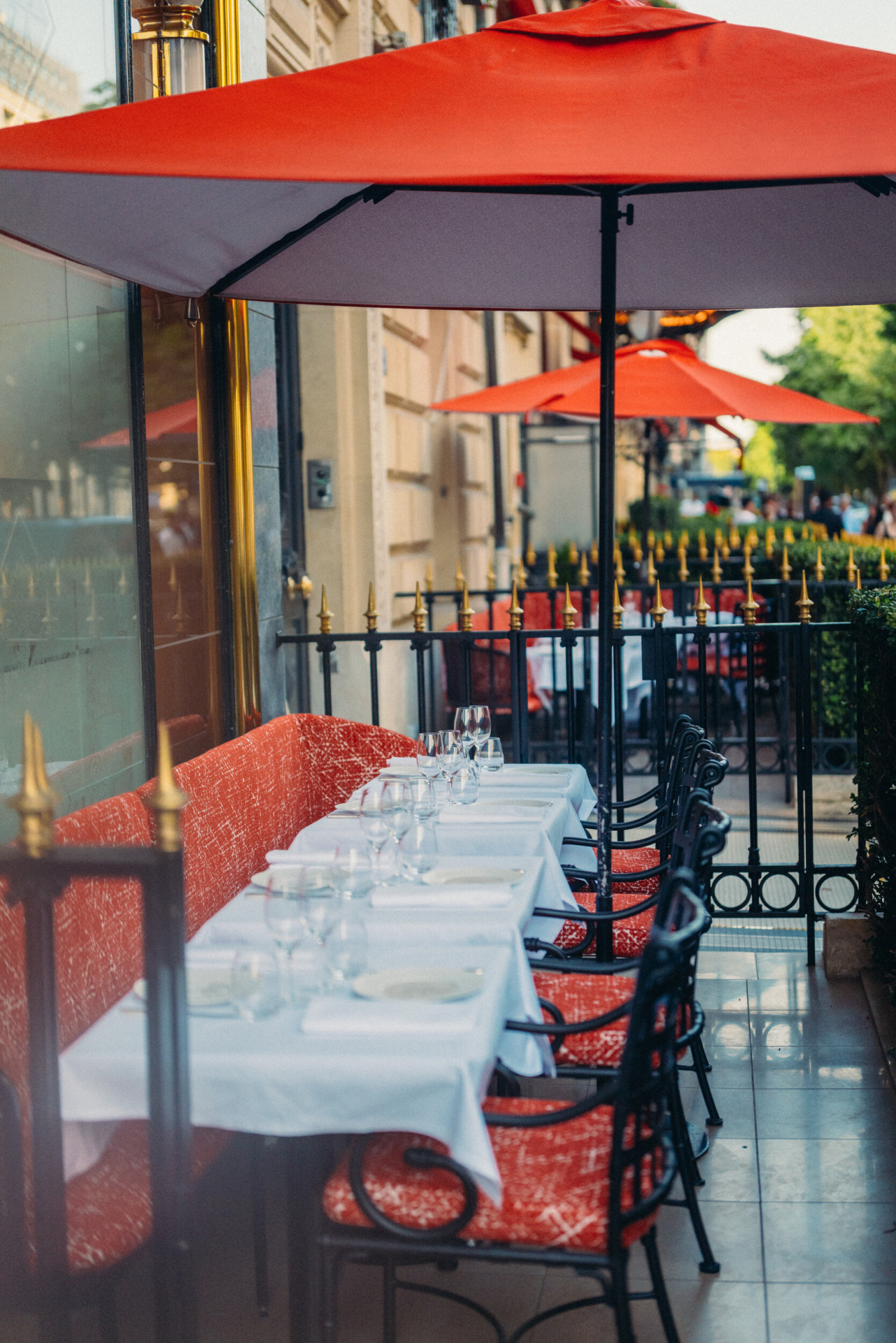 Relais Plaza's terrace with drawned up dining tables and Plaza red parasols, at Hotel Plaza Athénée, Paris