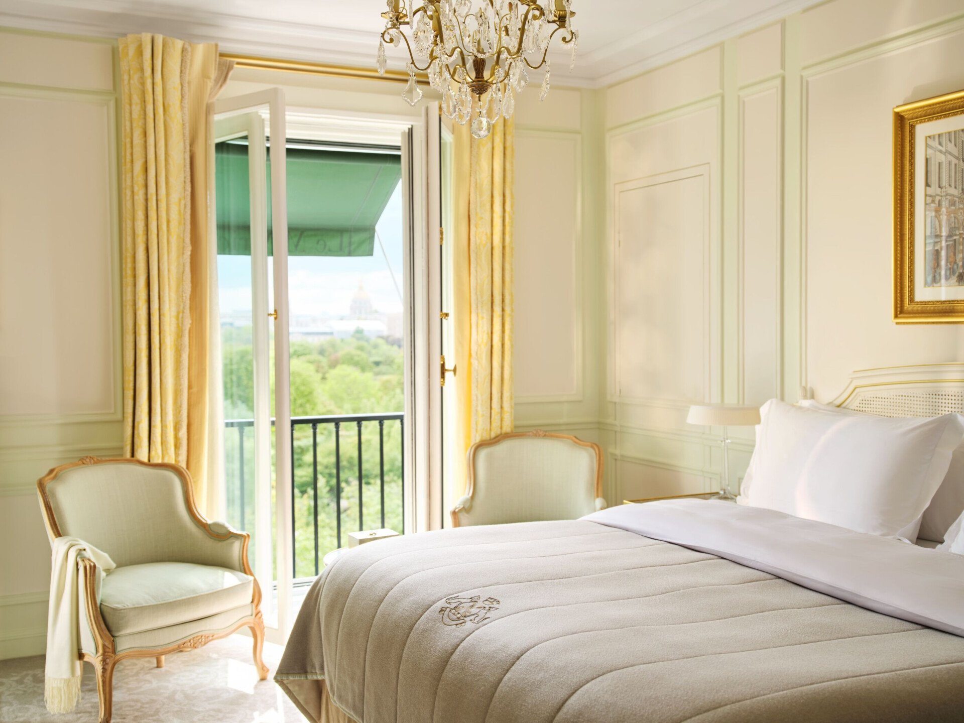 Bedroom in soft beige colours, two single sofas in light green are placed next to the window with yellow curtains, at Le Meurice, Paris