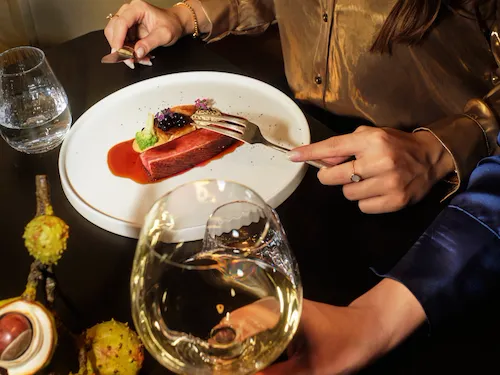 Woven by Adam Smith guests dinging waiting a Duck breast. The guest is wearing a gold shirt.