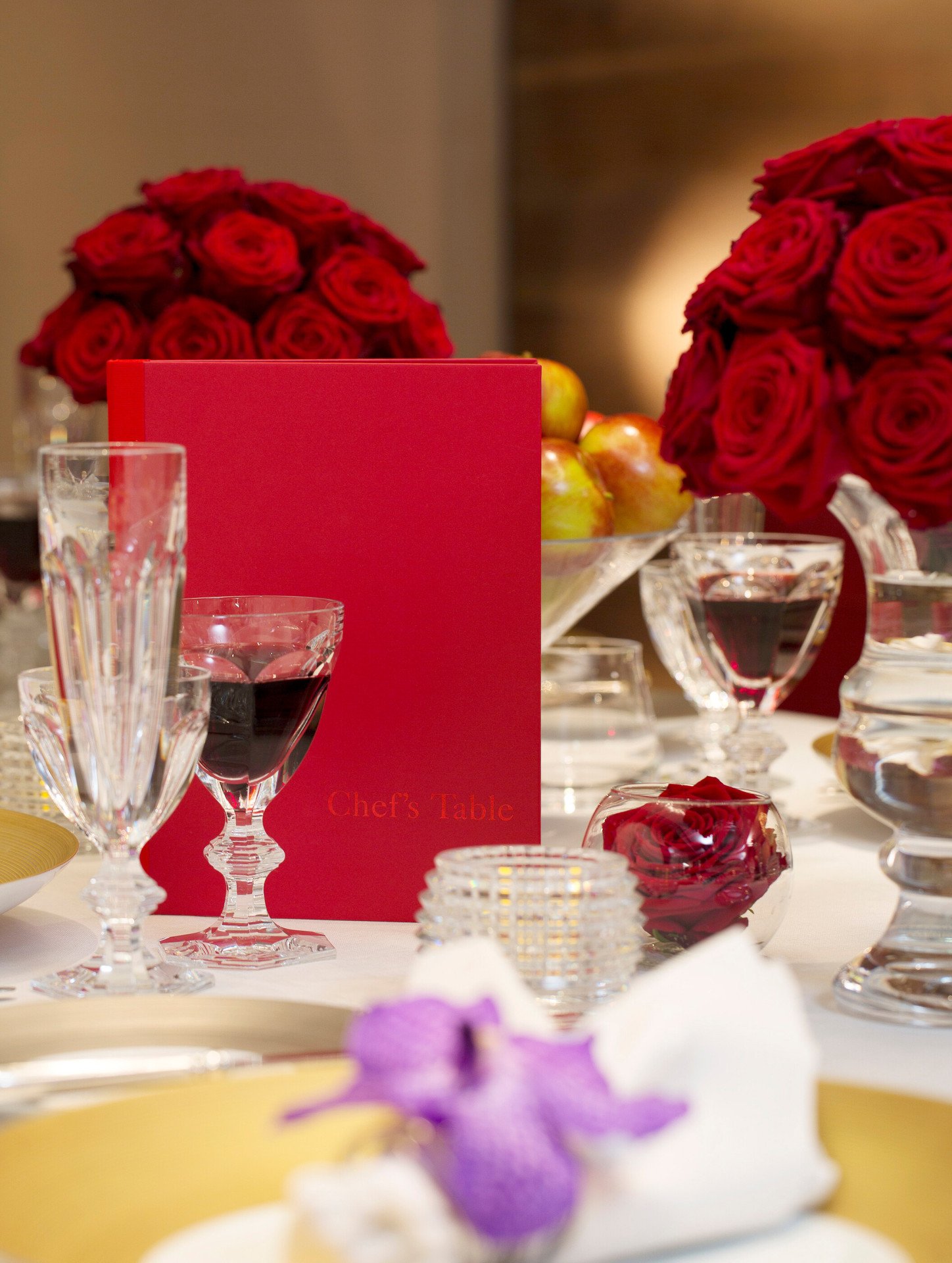 Chef's Table detail white roses, champagne flutes, dinner setup