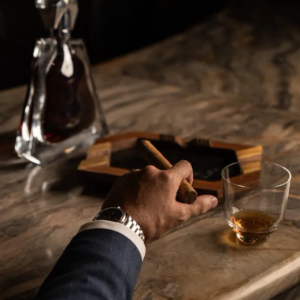 Images depicting Txakolina bar details at The Lana, Dorchester Collection, Dubai, including cigar, drink offerings and vinyl.