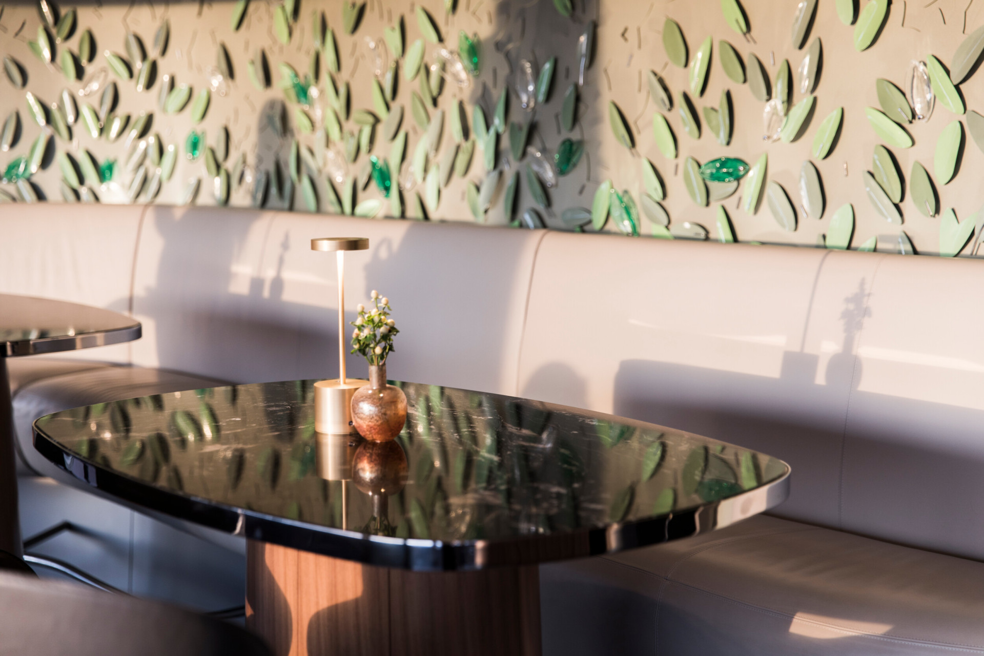 Interior of Il Giardino Bar with table and vertical garden wall  with metal leaves at Hotel Eden, Rome