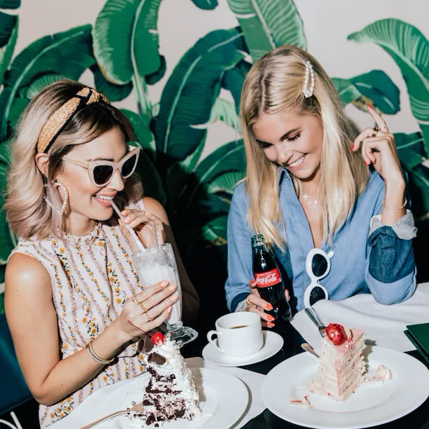 Friends eating cake and drinking milkshakes in The Fountain Coffee Room