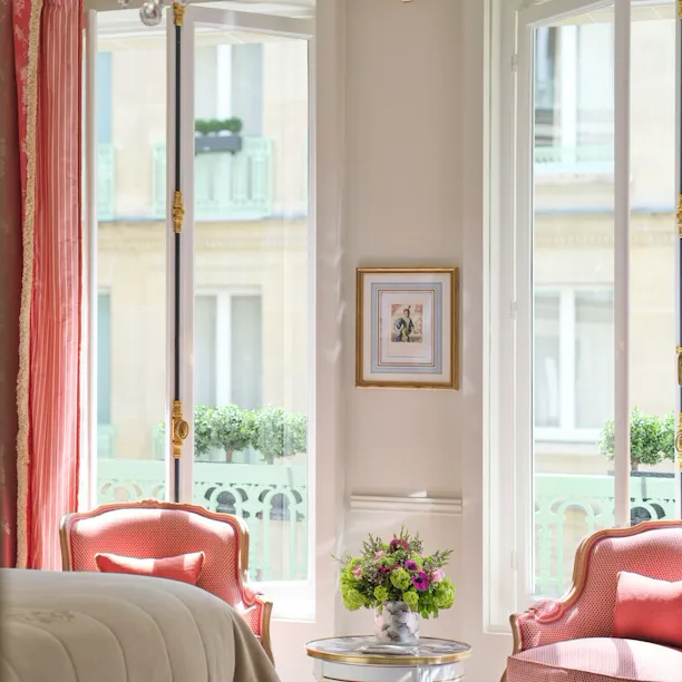 Highlighting of a deluxe room with the view on the chairs matching with the curtain in front of the windows, at Le Meurice, Paris