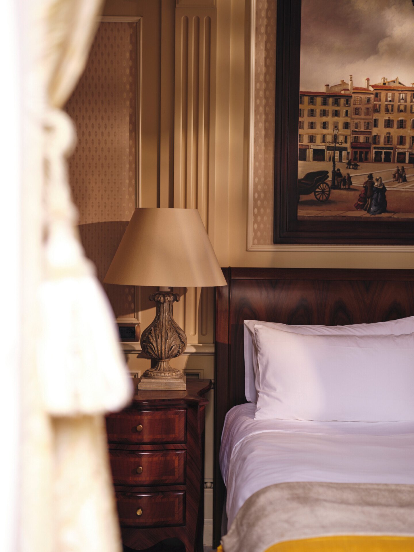 Detail of Premium Room showing partial bed and a lamp