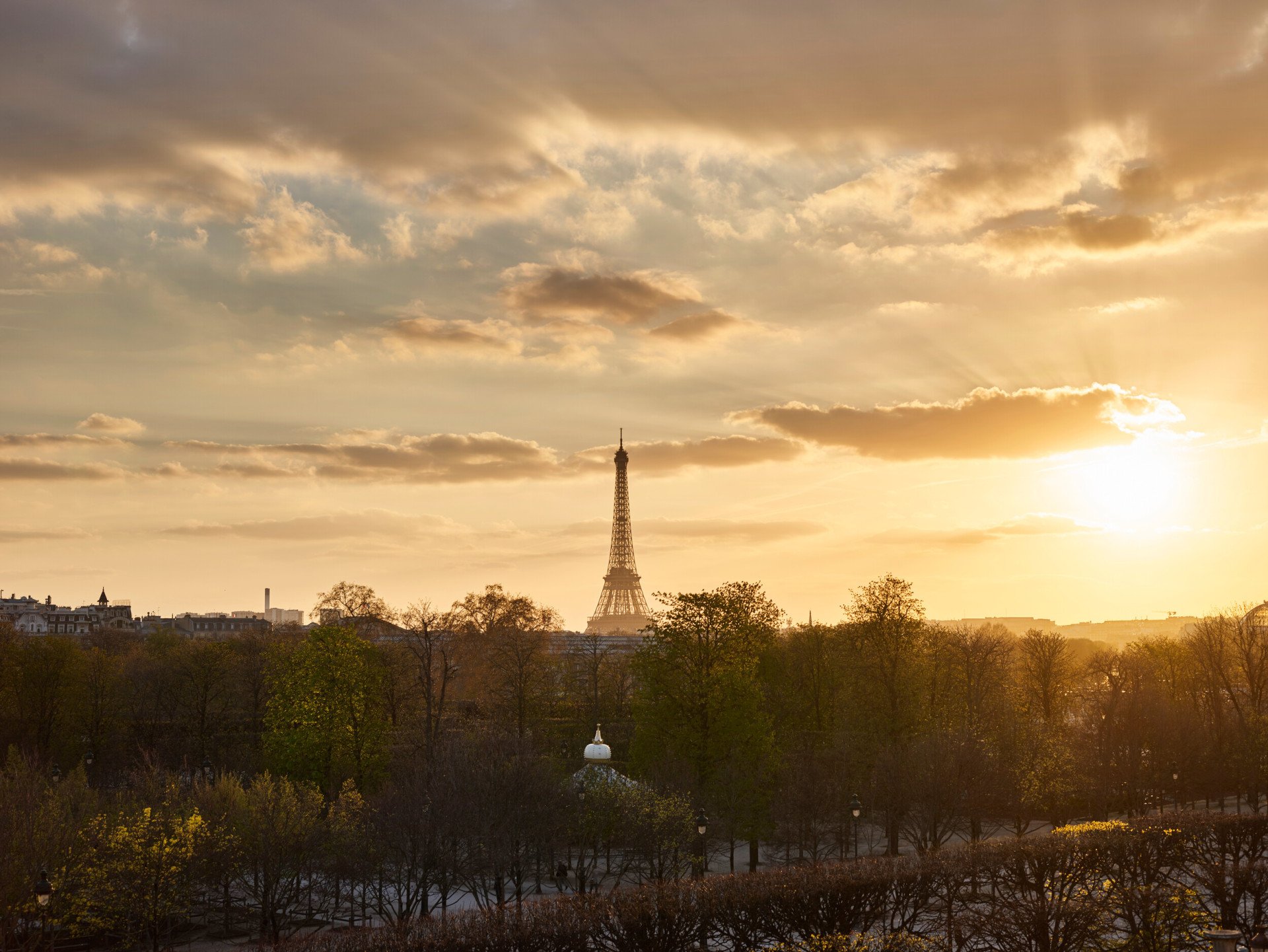 Distant view of the Eiffel tower at sunset with golden light from the Heritage Suite.  At Le Meurice, Paris.
