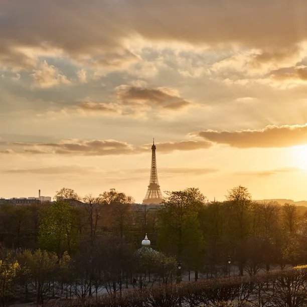 Distant view of the Eiffel tower at sunset with golden light from the Heritage Suite. At Le Meurice, Paris.