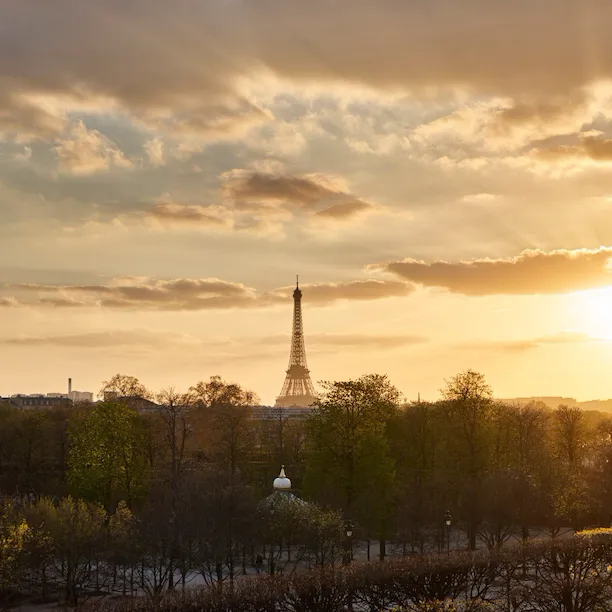 Distant view of the Eiffel tower at sunset with golden light from the Heritage Suite. At Le Meurice, Paris.