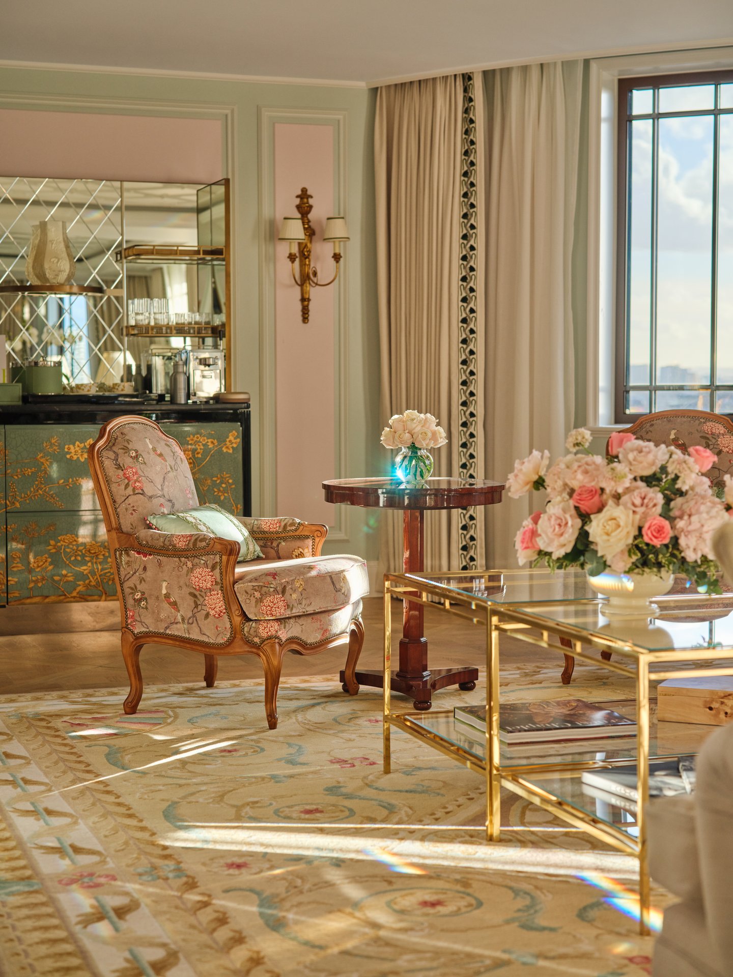Elegant living room with a floral arrangement, sunlight, vintage furniture, and classic decor.
