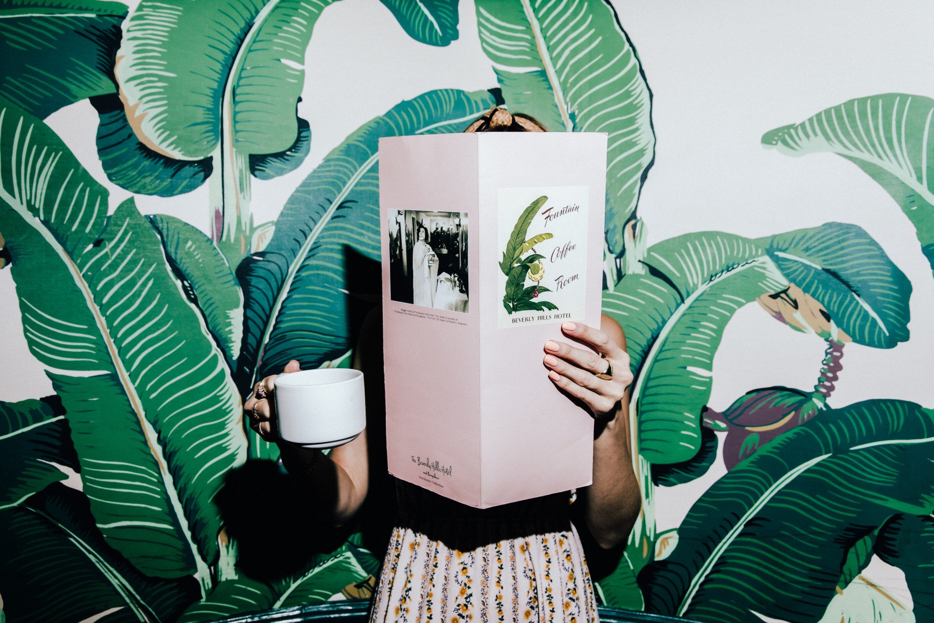 Woman reading menu and drinking coffee in The Fountain Coffee Room 
