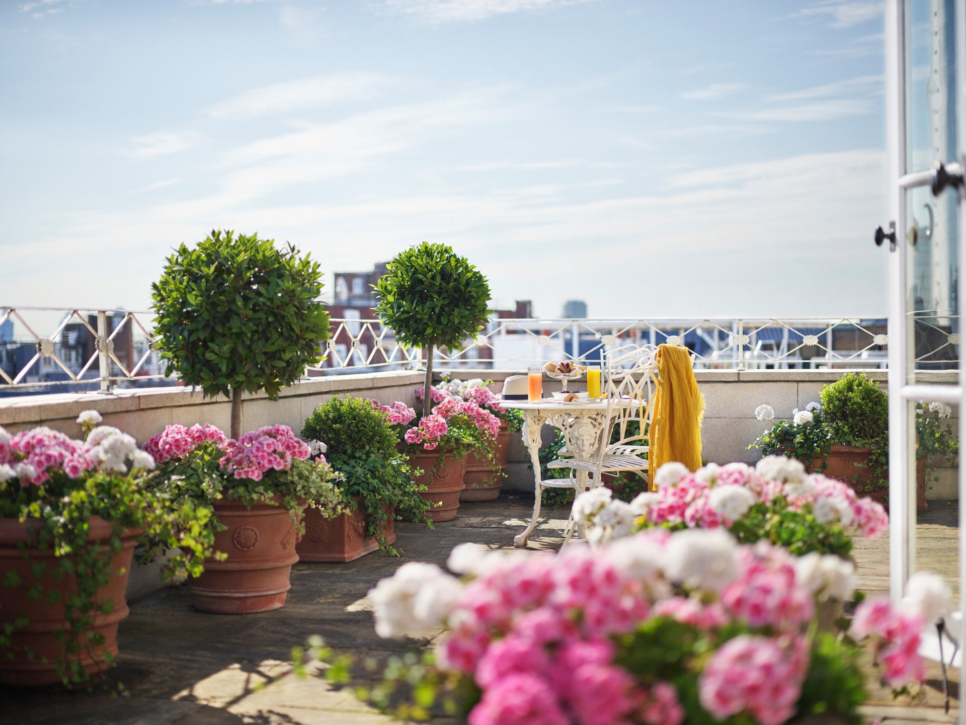 Oliver Messel suite sunny terrace with pink flower pots at The Dorchester, London